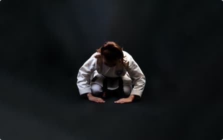 Judoka à genoux sur fond noir